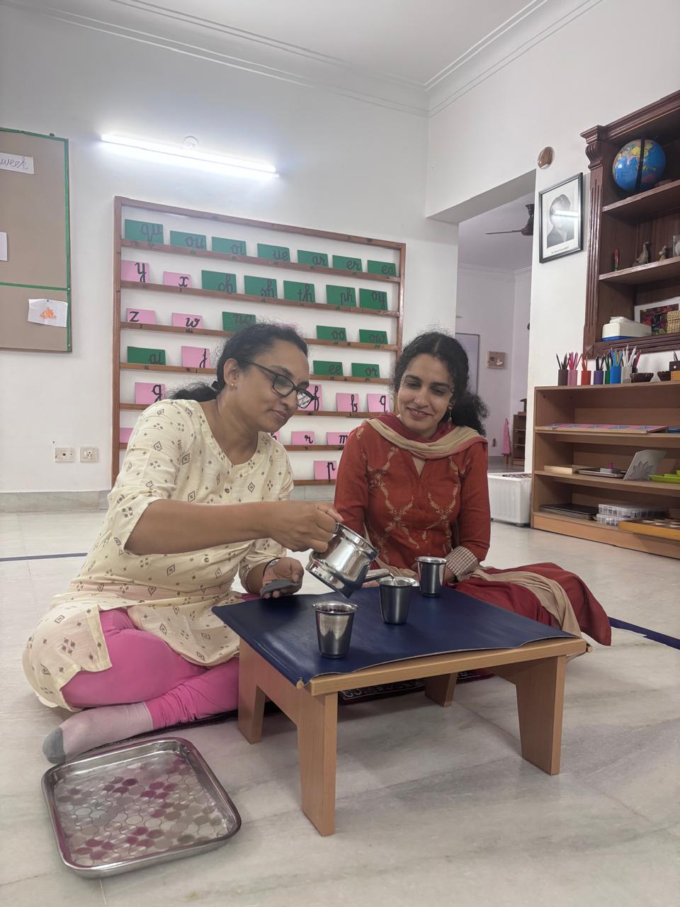 Montessori trainees reviewing a tabletop classroom material in the FTTA training room