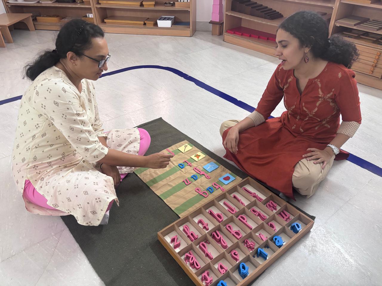 Montessori educator guiding a trainee through a number board lesson at FTTA