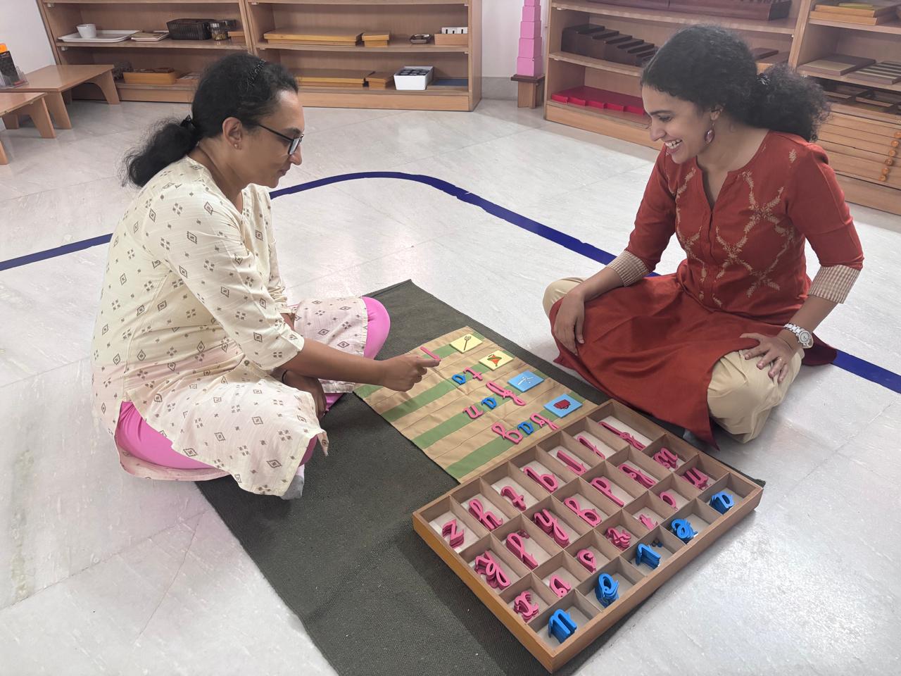 Trainer and trainee discussing Montessori bead materials during guided practice