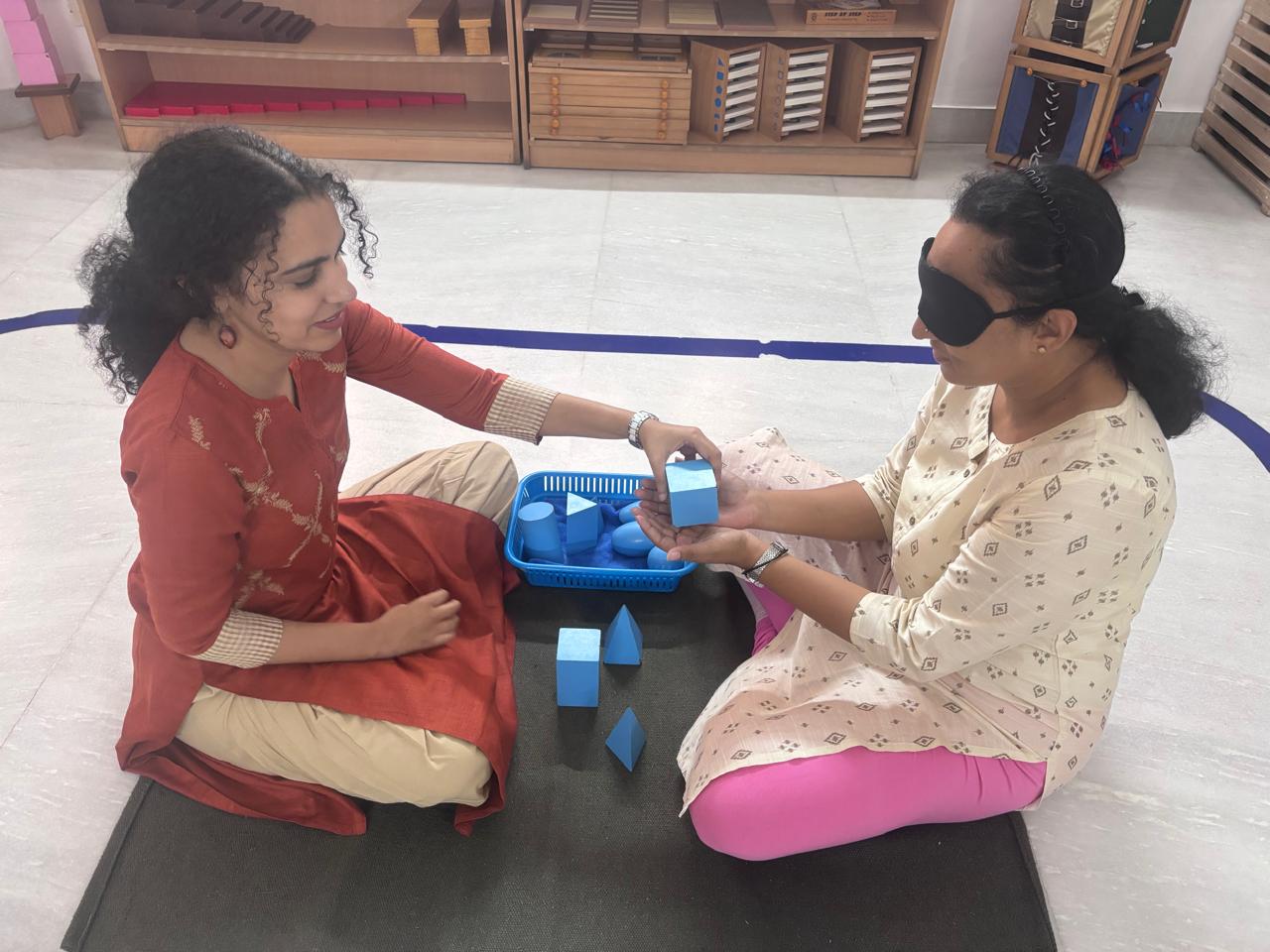 Montessori practical sensorial material demonstration between trainer and trainee
