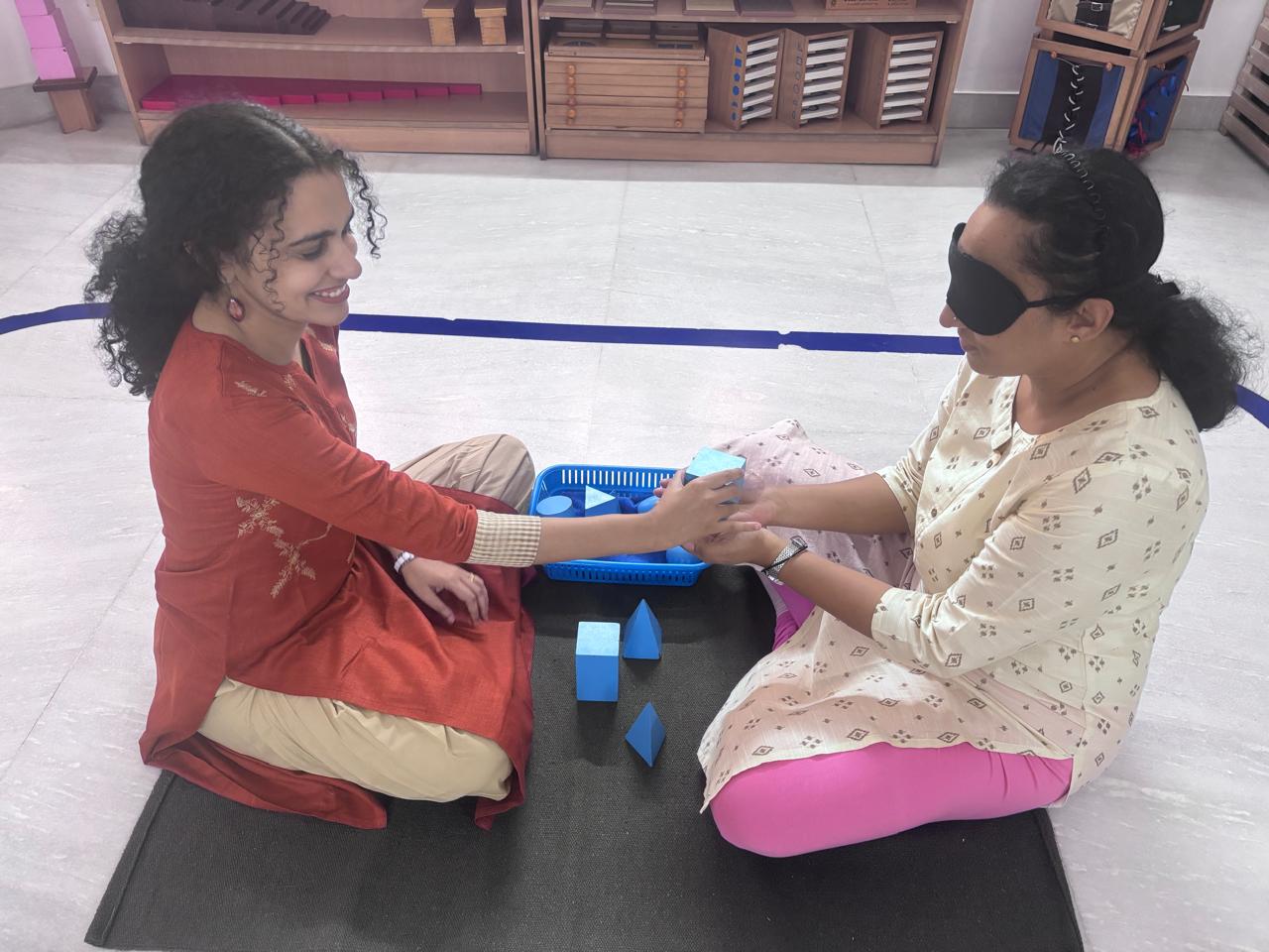 FTTA trainer and trainee presenting a blue sensorial Montessori material